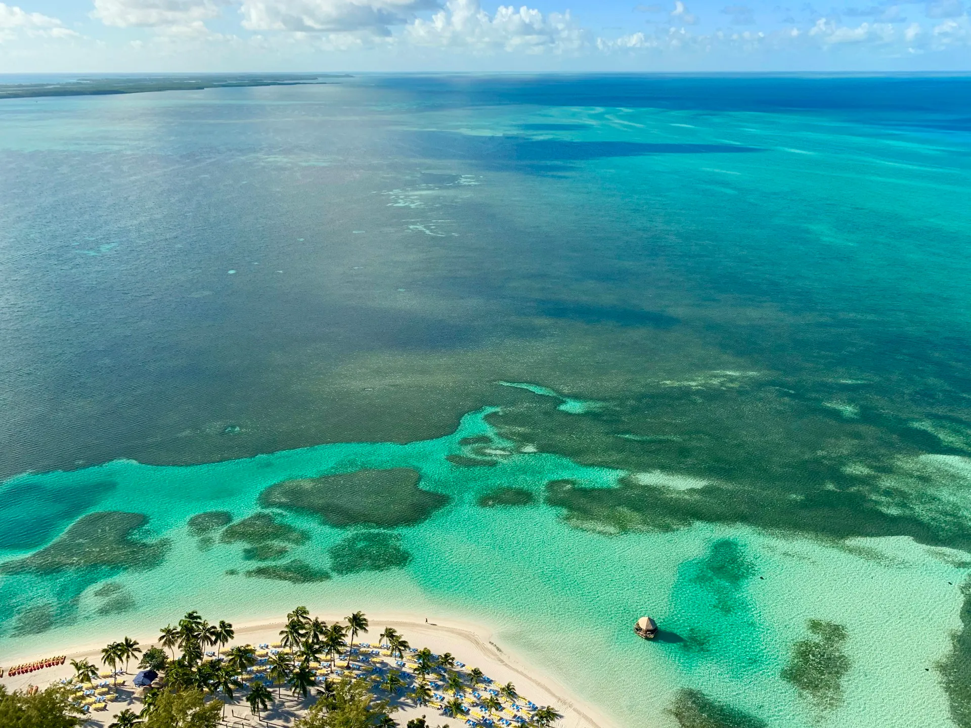Aerial view of a quiet Cat Island beach with an anchored boat