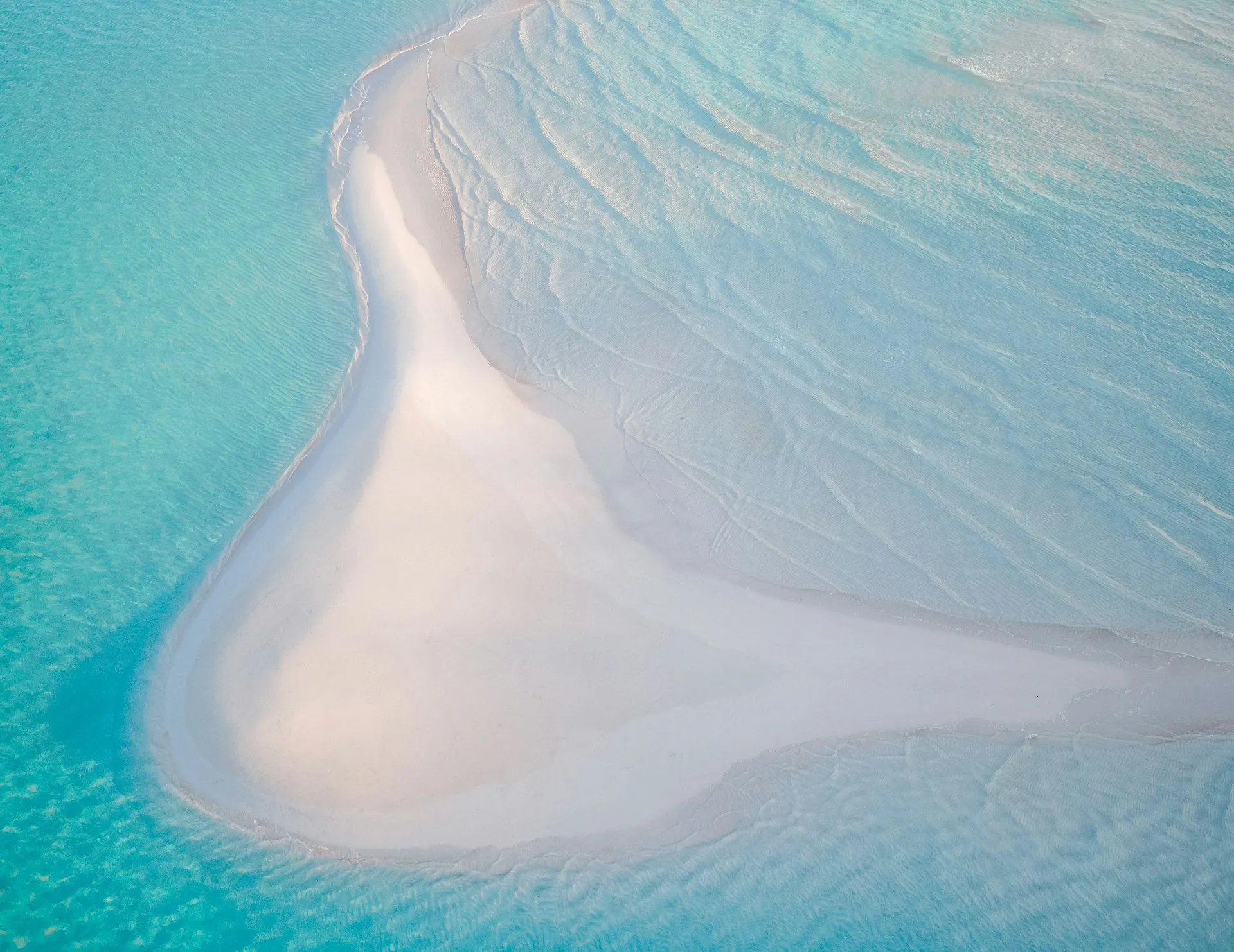 Aerial view of a blush-pink sandbar curving into turquoise water, Eleuthera